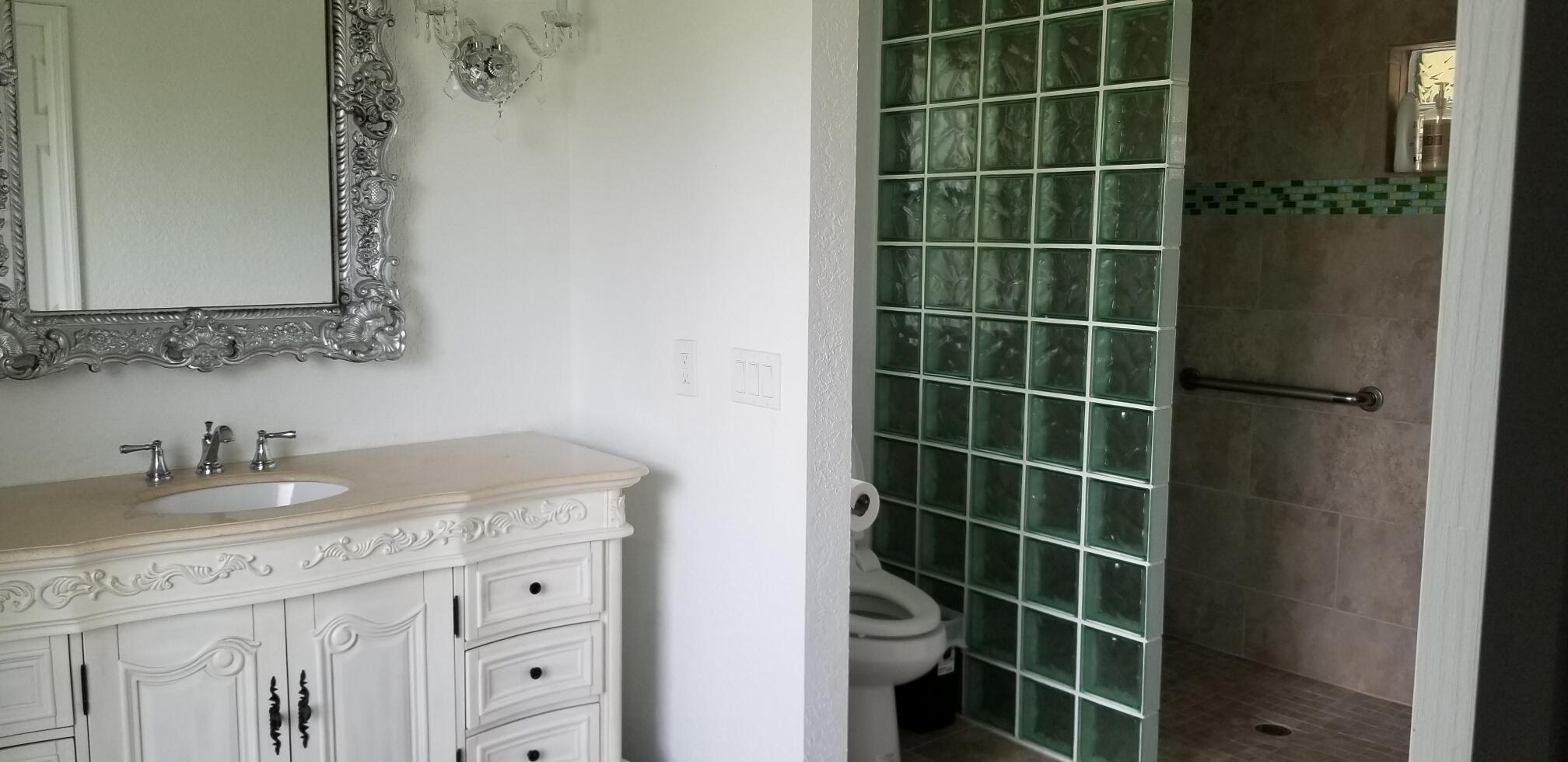 5425 Koblegard Road Fort Pierce, FL 34951 - Photo 23 of 33 a bathroom with a granite countertop sink a shower and a mirror
