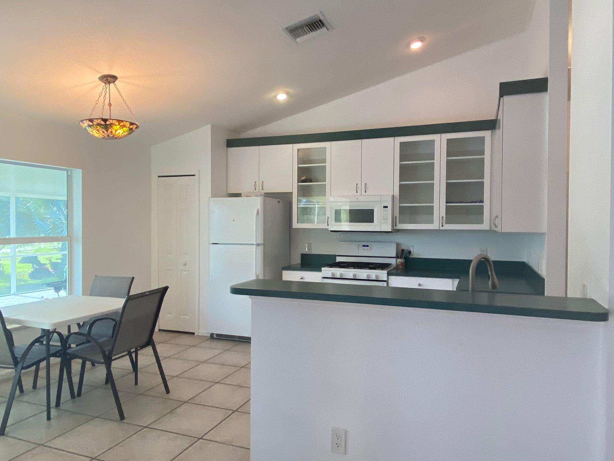 5425 Koblegard Road Fort Pierce, FL 34951 - Photo 7 of 33 a kitchen with granite countertop a sink and a refrigerator