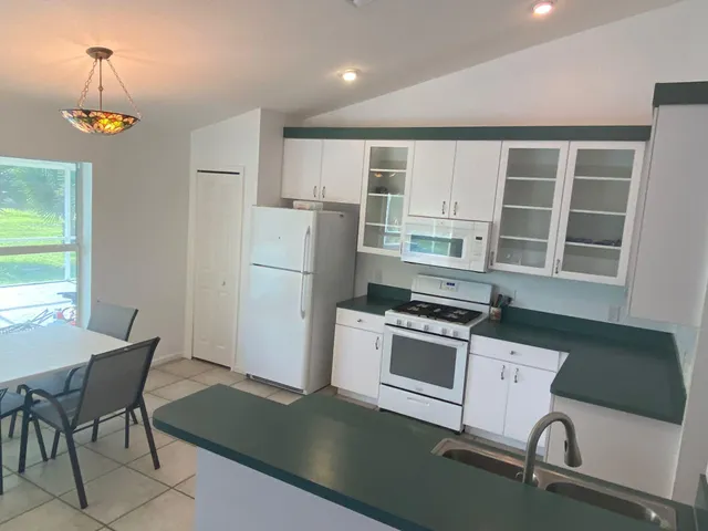 a kitchen with a refrigerator stove and white cabinets