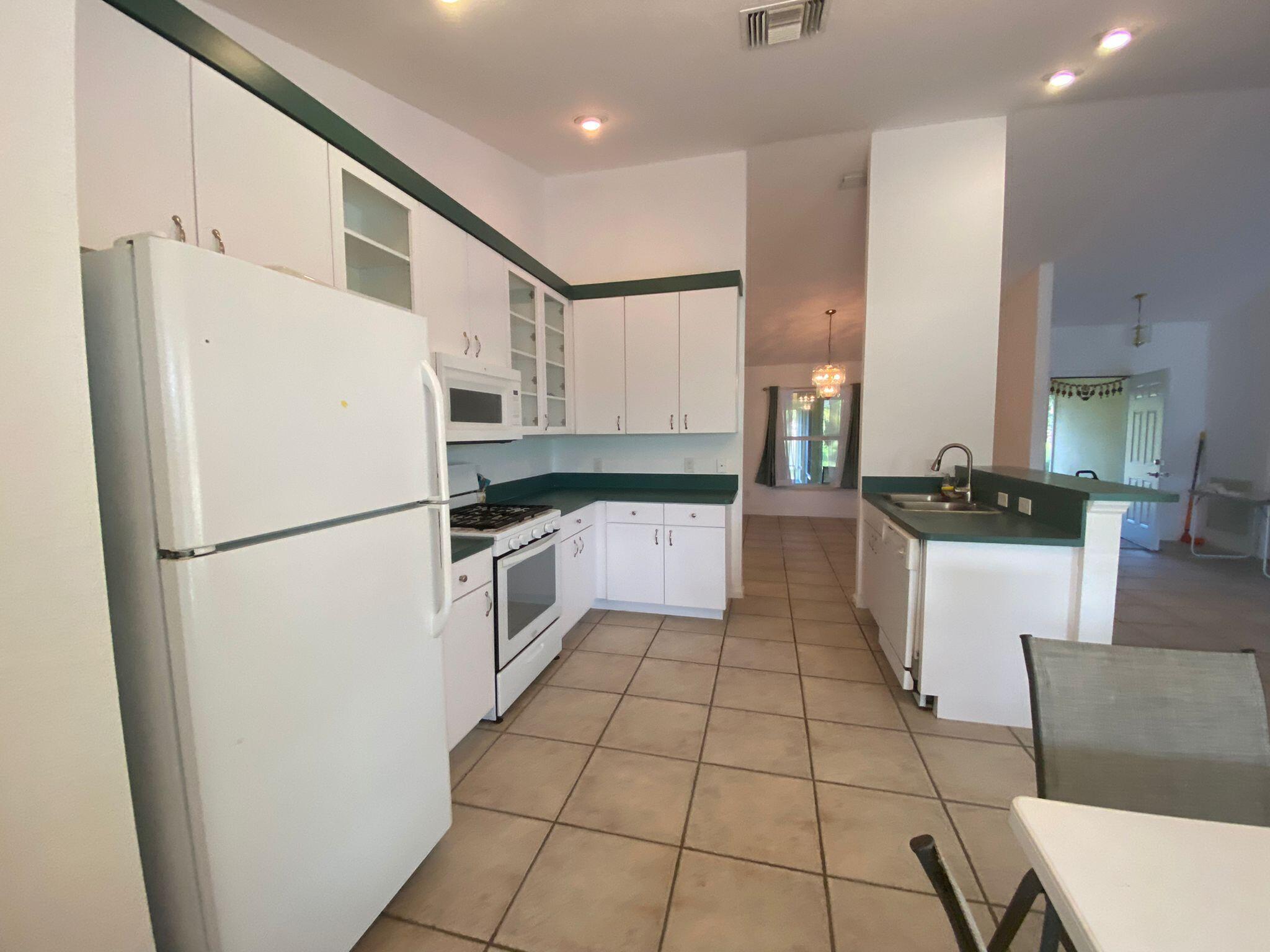 5425 Koblegard Road Fort Pierce, FL 34951 - Photo 10 of 33 a kitchen with stainless steel appliances a refrigerator sink and cabinets