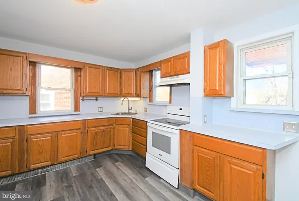 a kitchen with stainless steel appliances sink cabinets and a large window