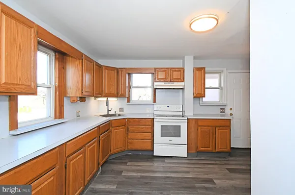 a large kitchen with stainless steel appliances granite countertop a stove a sink and a dishwasher next to a window