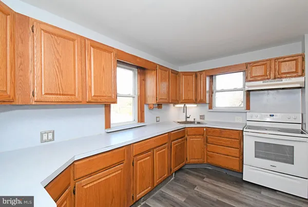 a kitchen with stainless steel appliances granite countertop a sink and cabinets with wooden floor