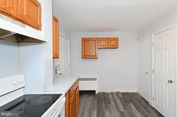 a view of a hallway to a livingroom with furniture wooden floor and staircase