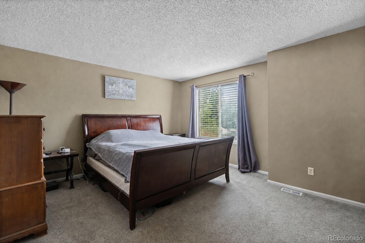 10565 Hyacinth Place Highlands Ranch, CO 80129 - Photo 17 of 33 a bed sitting in a bedroom next to a window