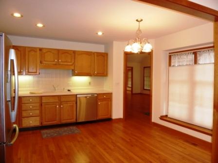2618 Miller Road Geneva, IL 60134 - Photo 4 of 16 a kitchen with stainless steel appliances granite countertop a refrigerator a sink dishwasher a stove and a dining table with wooden floor