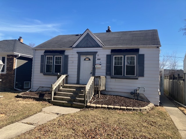 a view of a house with a barbeque and wooden fence