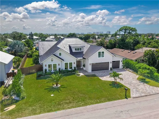 aerial view of a house with a big yard plants and large trees