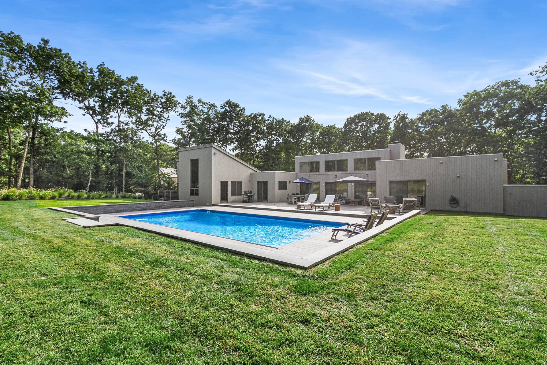 a view of a house with pool and a yard