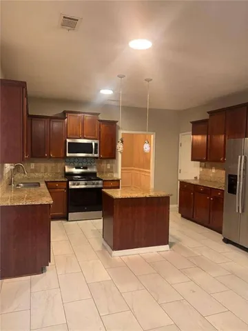 a large kitchen with stainless steel appliances and a sink