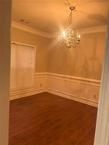 a view of a room with wooden floor and chandelier