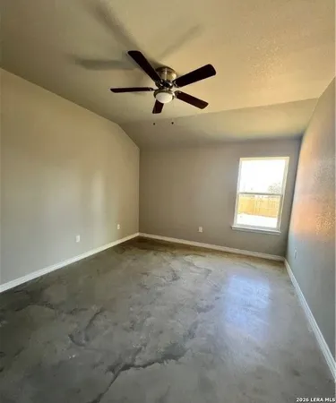 an empty room with windows and fan
