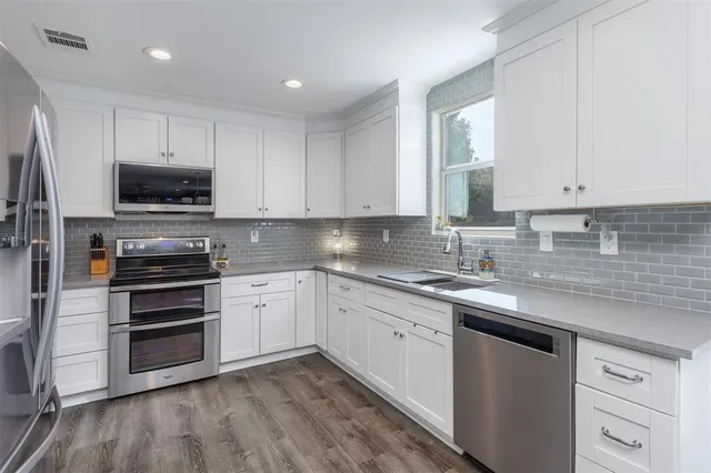 a kitchen with appliances a sink and cabinets
