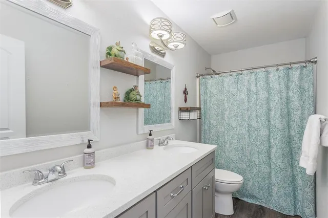 a bathroom with a granite countertop sink a toilet and a mirror