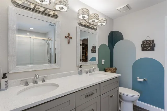 a bathroom with a toilet sink and mirror