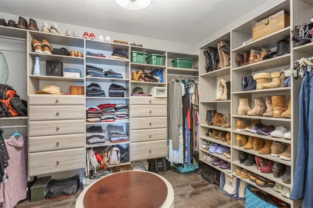 a view of walk in closet with clothes and shoes