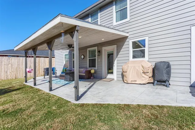 a view of a house with a patio and a yard
