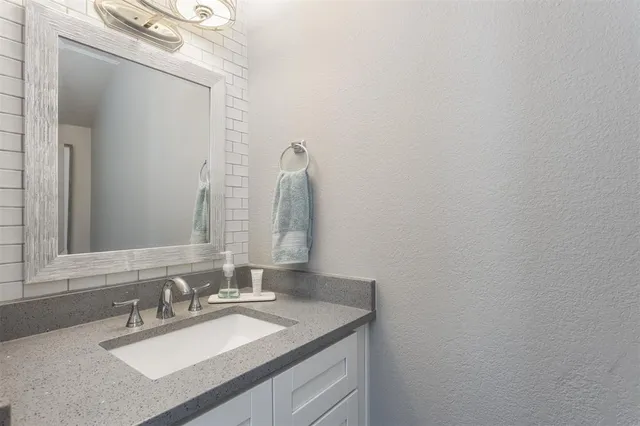 a bathroom with a sink vanity and a mirror