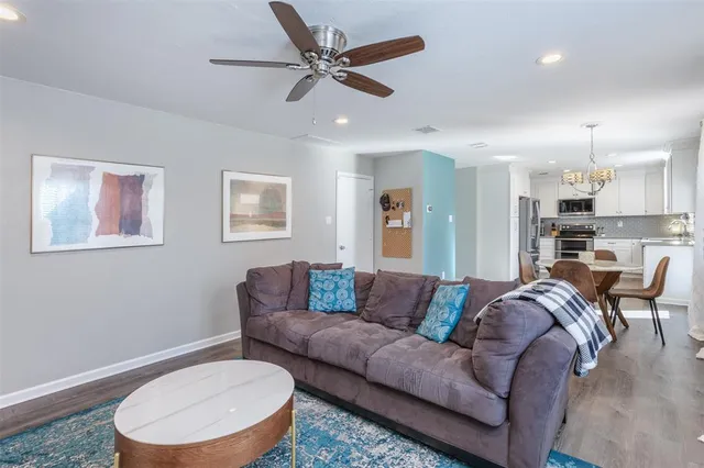 a living room with furniture and a view of kitchen
