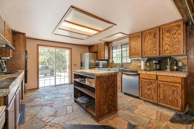 a kitchen with sink cabinets and stove top oven
