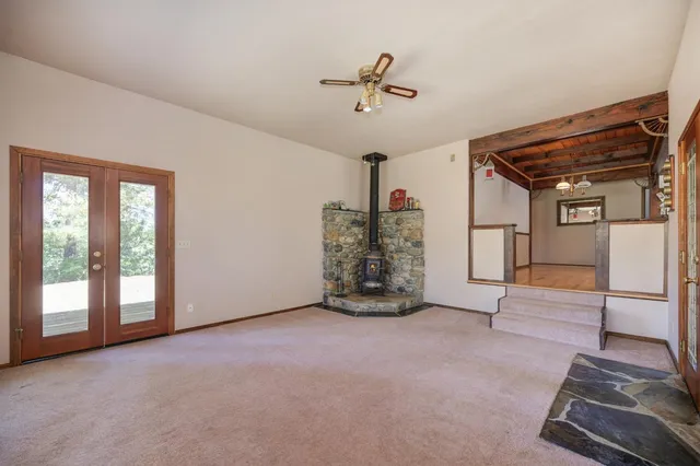an empty room with fireplace and fan