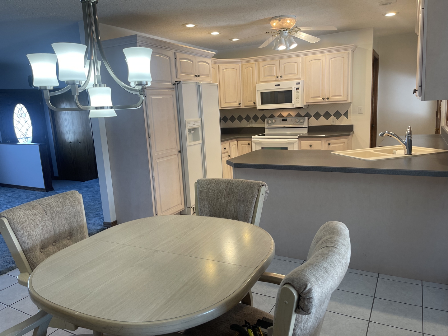 1308 Sunset Drive Peru, IL 61354 - Photo 4 of 19 a kitchen with stainless steel appliances granite countertop a dining table chairs and a refrigerator