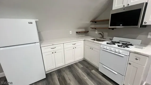 a kitchen with white cabinets stainless steel appliances and a sink