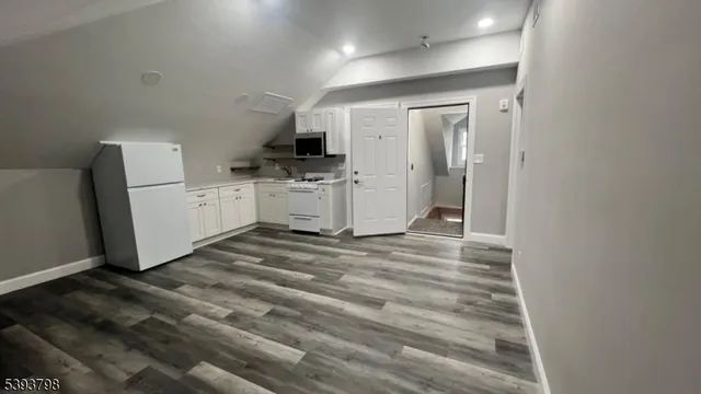 a room with a refrigerator and a stove top oven