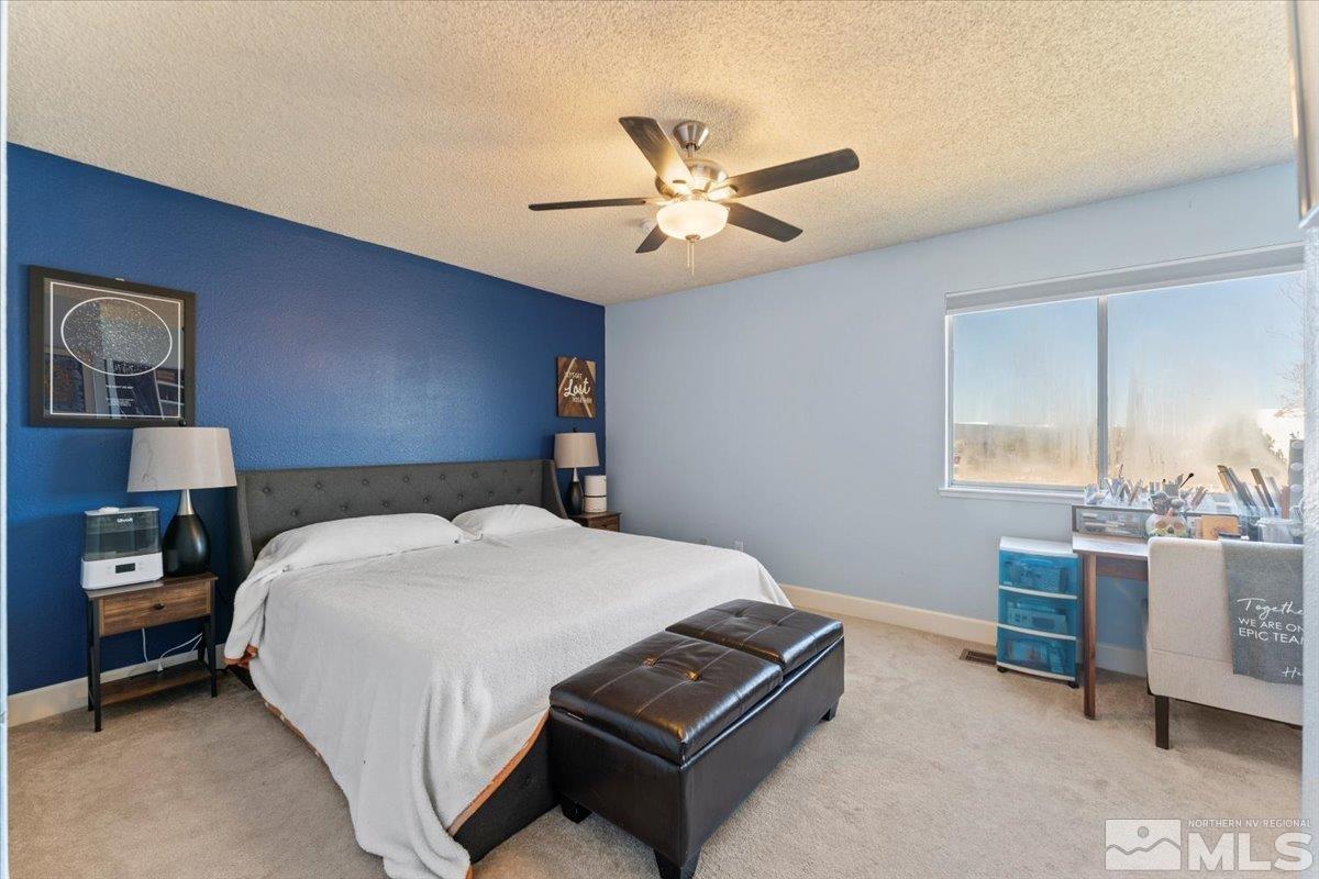 4435 Perro Lane Reno, NV 89502 - Photo 13 of 35 a bedroom with a bed and a chandelier