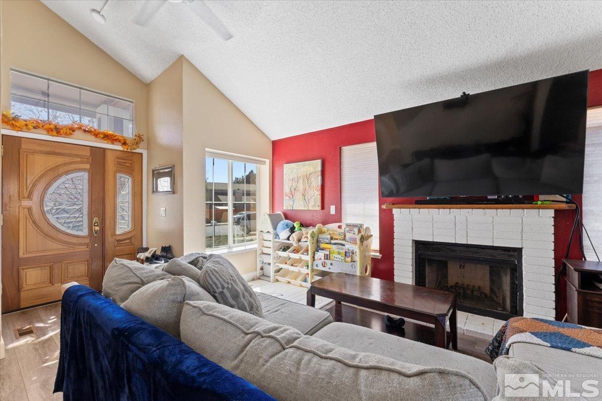 4435 Perro Lane Reno, NV 89502 - Photo 4 of 35 a living room with furniture a fireplace and a flat screen tv