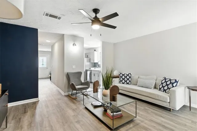 a living room with furniture and a wooden floor