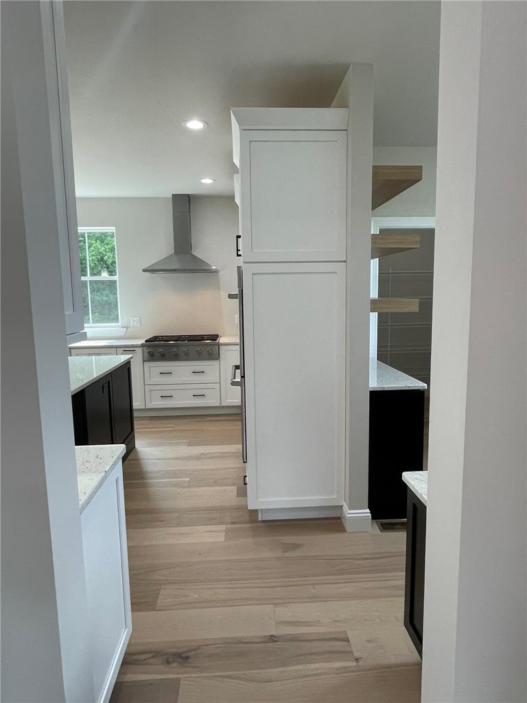 5043 Chapmans Road Orefield, PA 18069 - Photo 10 of 30 A clean-lined kitchen showcases a range hood and recessed lighting over light hardwood flooring.
