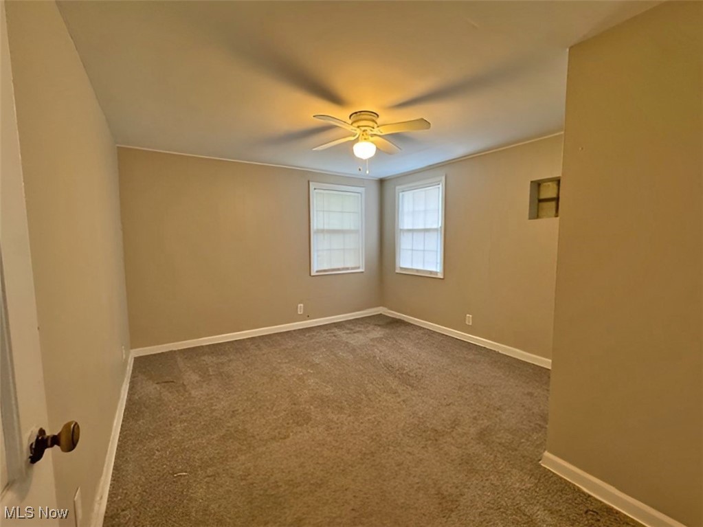 254 Howland Wilson Road Southeast Warren, OH 44484 - Photo 7 of 9 Carpeted empty room with ceiling fan