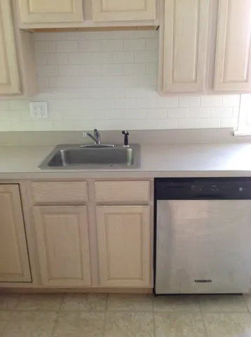 a kitchen with white cabinets and sink