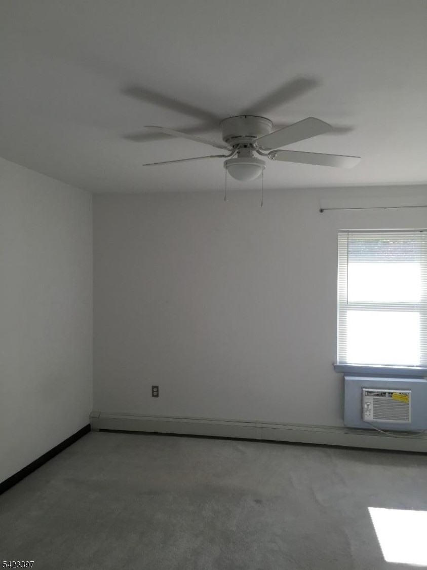 1130 Valley Road, Unit 2B Wayne, NJ 07470 - Photo 4 of 18 a view of a livingroom with a ceiling fan and window