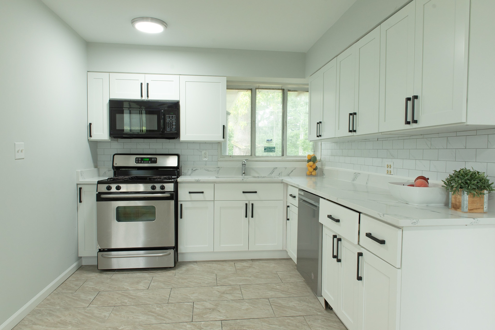846 Waukegan Road Northbrook, IL 60062 - Photo 9 of 29 a kitchen with white cabinets stainless steel appliances and a window