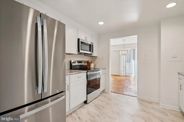 a kitchen with white cabinets and white appliances