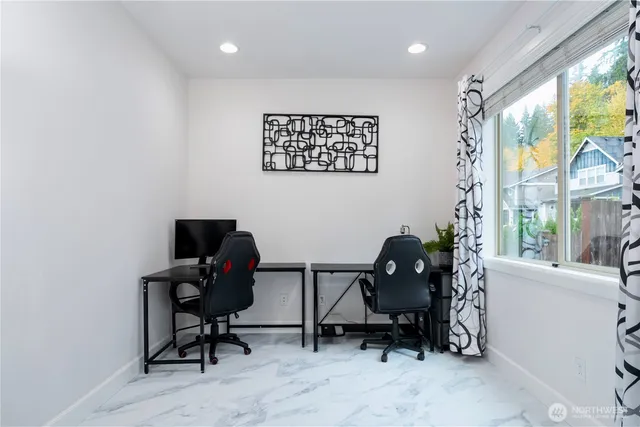 a view of a workspace with furniture and a window