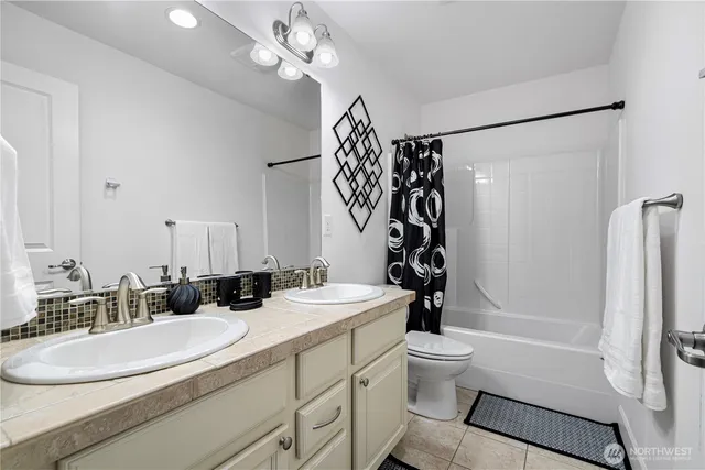 a bathroom with a sink a toilet a mirror a vanity and shower