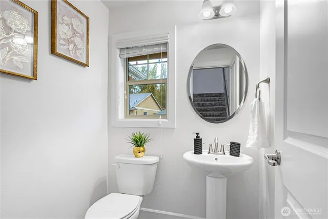 a bathroom with a toilet sink and mirror