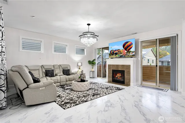 a living room with furniture a fireplace and a large window