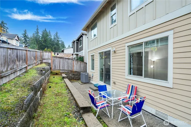 a view of a chair and tables in the back yard of the house
