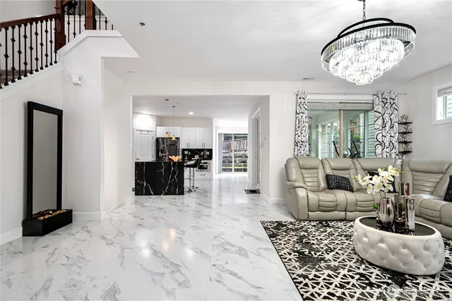 a living room with furniture a chandelier and a dining table