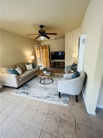 a living room with furniture a flat screen tv and a window