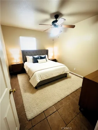 a bedroom with a bed and a ceiling fan