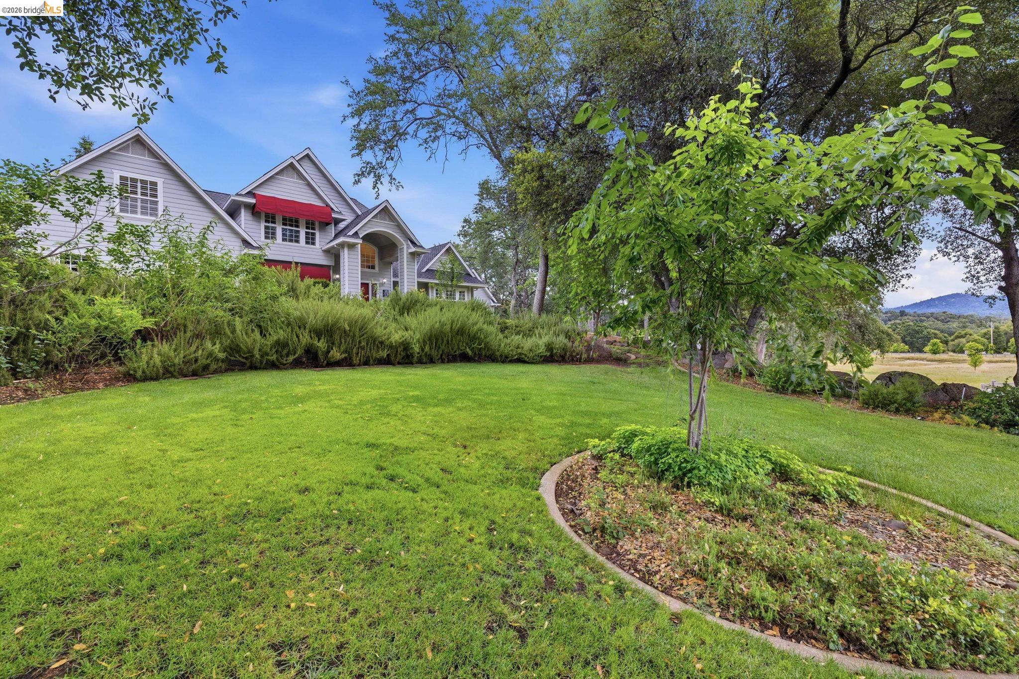 18450 Lambert Lake Road Sonora, CA 95370 - Photo 7 of 87 Expansive green lawn with a landscaped planting bed