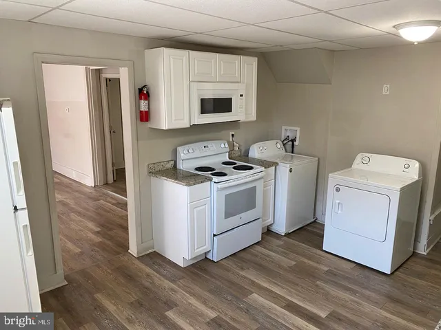 a view of kitchen with white cabinets and white appliances