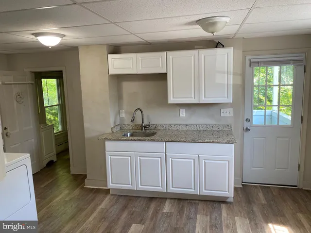 a kitchen with a sink cabinets and wooden floor