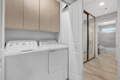 a utility room with cabinets washer and dryer