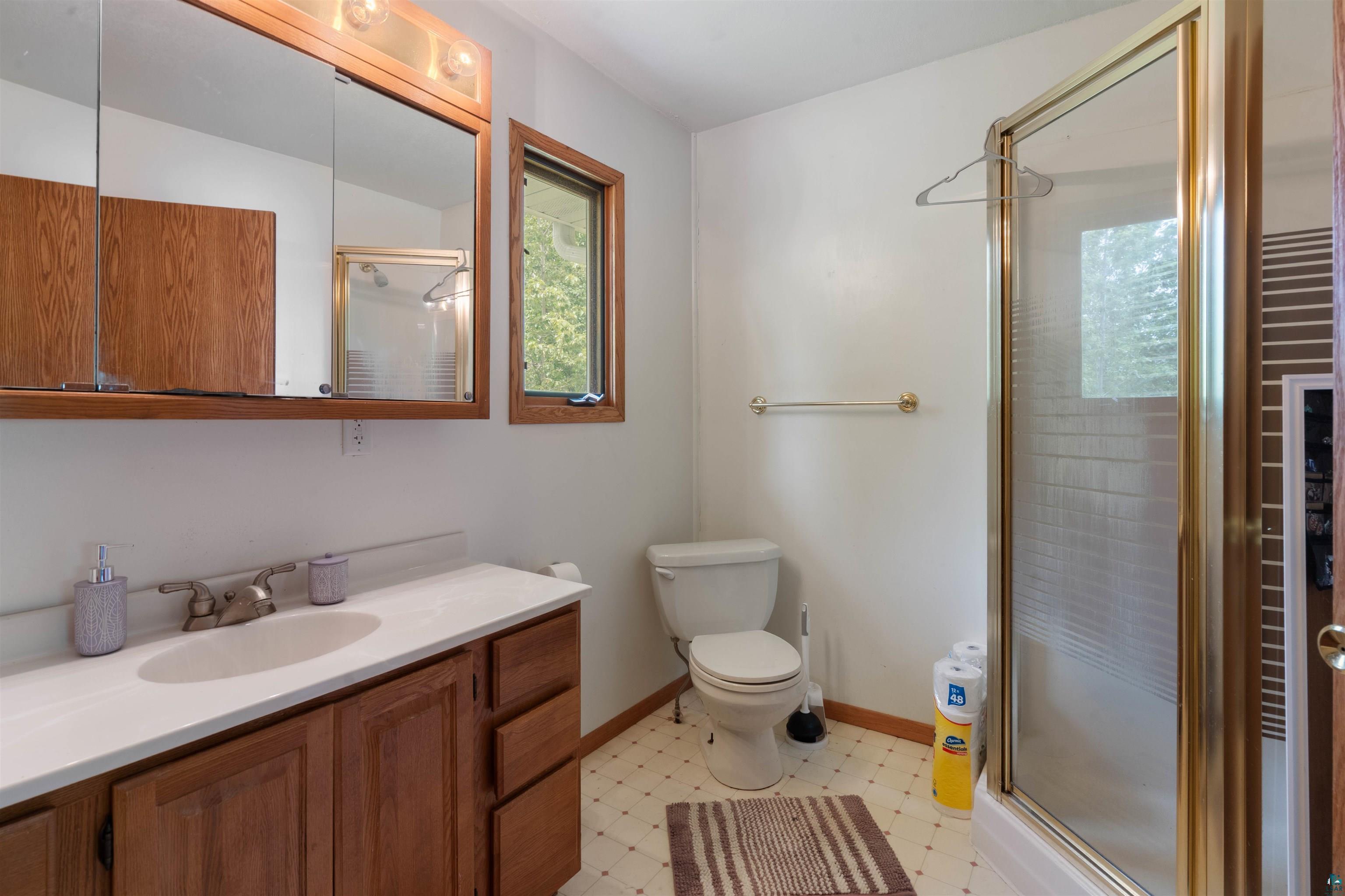 3711 Getchell Road Hermantown, MN 55811 - Photo 14 of 31 Bathroom featuring a vanity with wood-finish cabinetry, a single basin sink, and a light-toned countertop